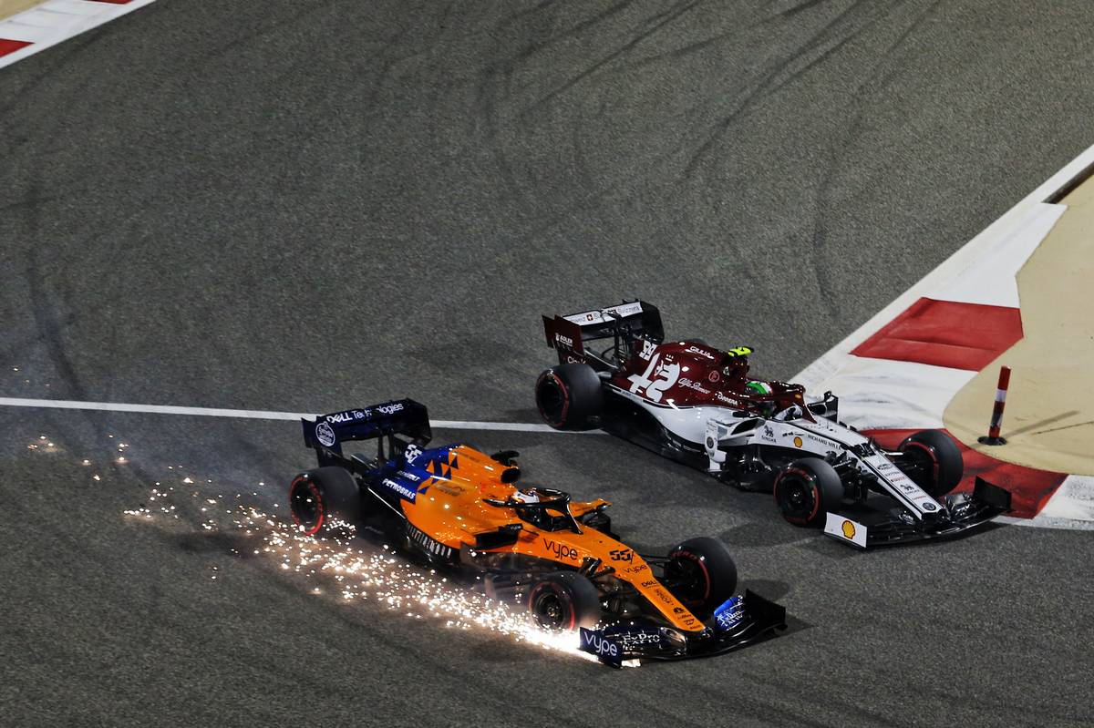 Carlos Sainz Jr (ESP) McLaren MCL34 sends sparks flying at the start of the race alongside Antonio Giovinazzi (ITA) Alfa Romeo Racing C38.