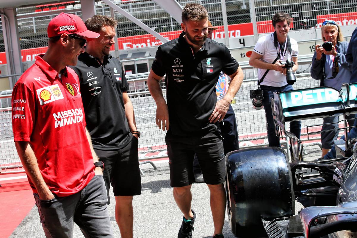 Sebastian Vettel (GER) Ferrari with members of the Mercedes AMG F1 team.
