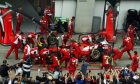 Ferrari practices a pit stop during a fans' pit lane walkabout session.