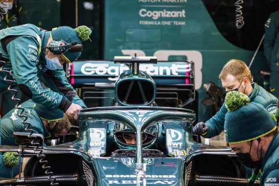 Mechanics work on the car of Lance Stroll, Aston Martin AMR21