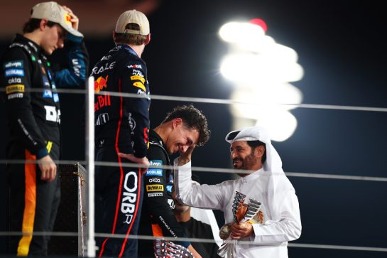 ABU DHABI, UNITED ARAB EMIRATES - DECEMBER 07: Mohammed ben Sulayem, FIA President congratulates 2025 F1 World Drivers Champion and Third placed Lando Norris of Great Britain and McLaren on the podium during the F1 Grand Prix of Abu Dhabi at Yas Marina Circuit on December 07, 2025 in Abu Dhabi, United Arab Emirates. (Photo by Mark Thompson/Getty Images)